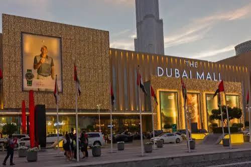 The Dubai Mall exterior at dusk with the Burj Khalifa behind it