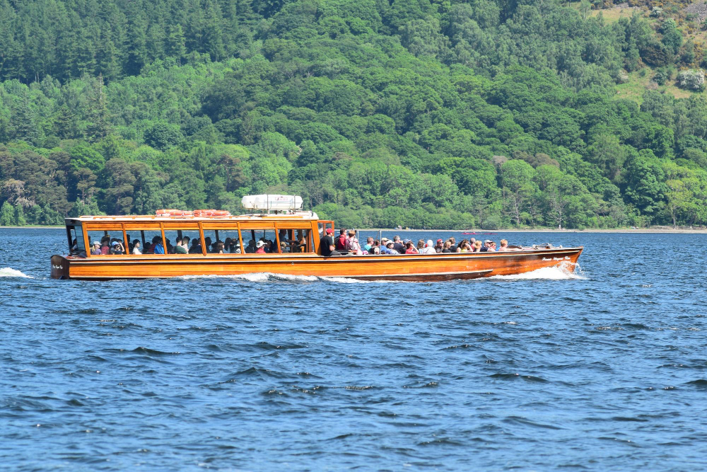 Wooden tour boat carrying passengers along a Connemara lake