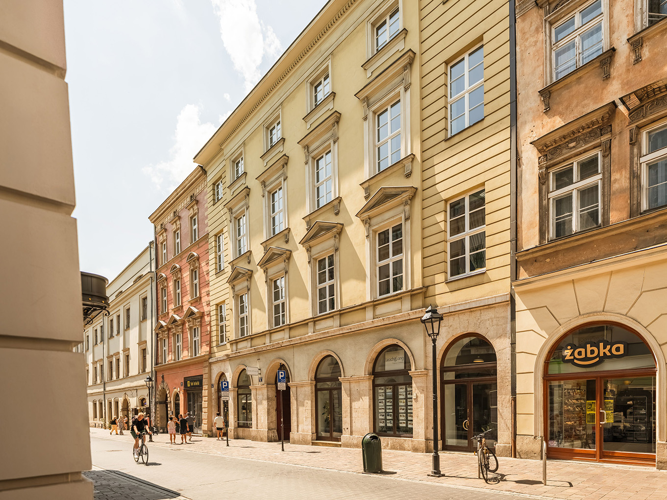 Historic street facade with ground-floor shops in Kraków's old town