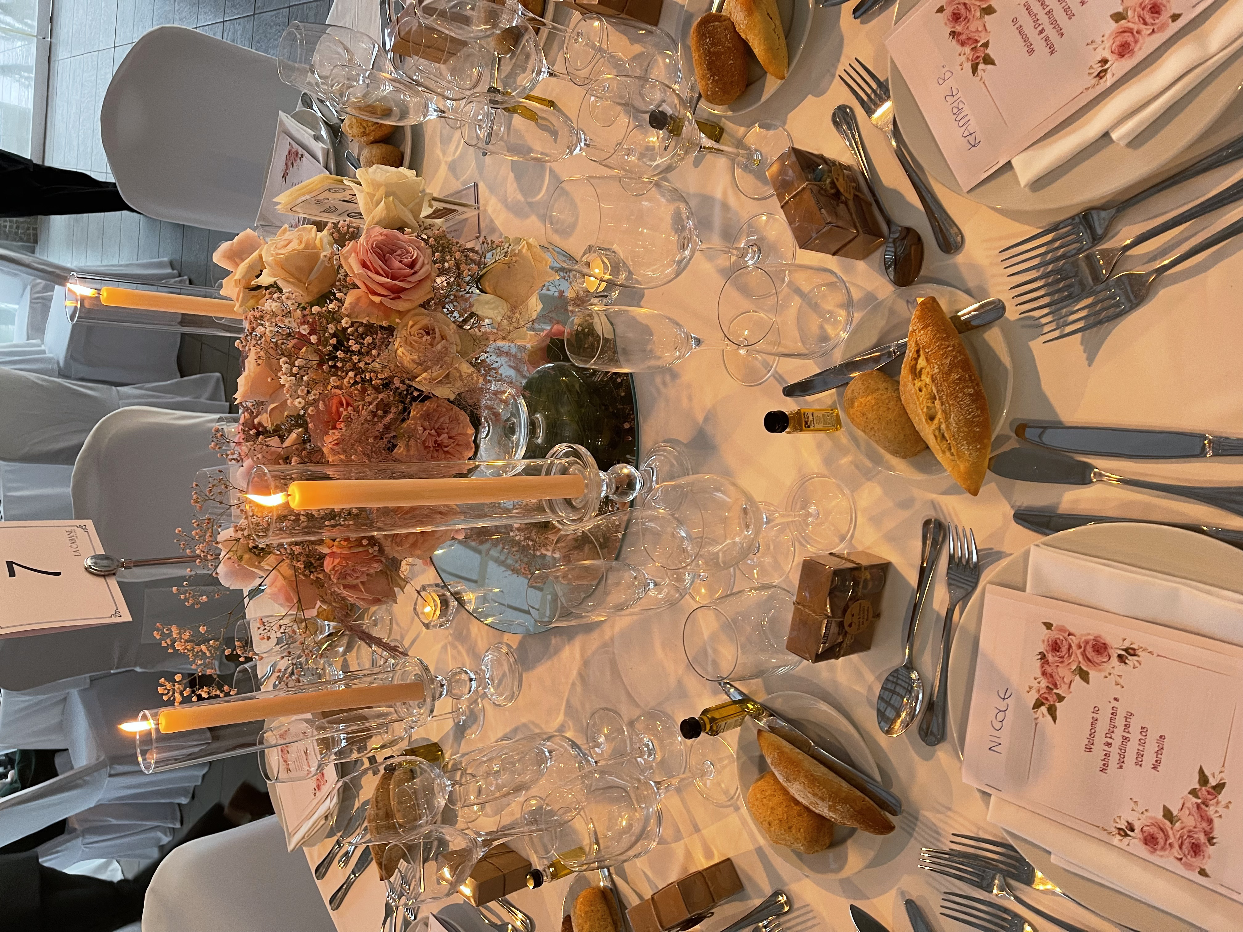 Reception table setting with candles and pink roses at a Marbella wedding